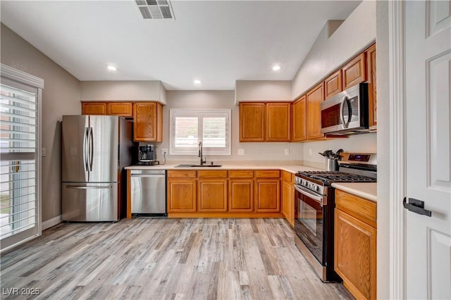 kitchen with light countertops, appliances with stainless steel finishes, a sink, and visible vents