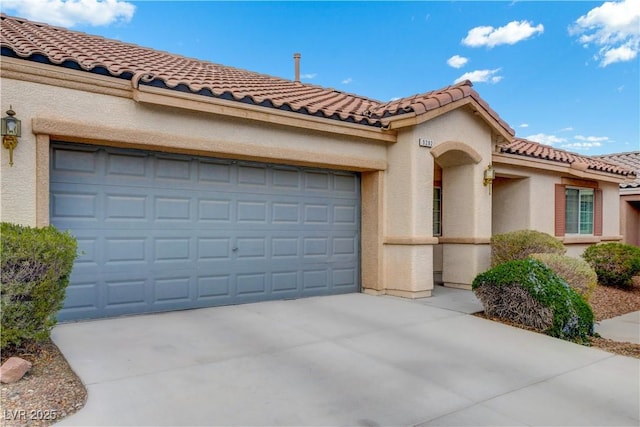 view of front facade featuring a garage, a tile roof, driveway, and stucco siding