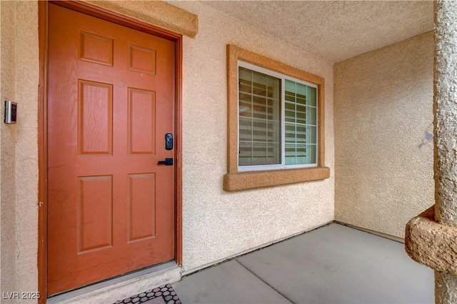 doorway to property featuring stucco siding