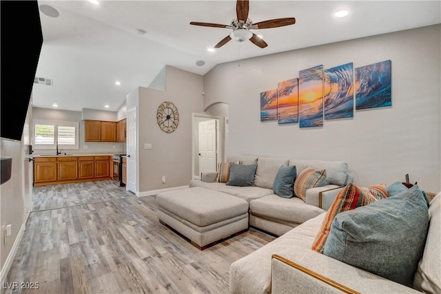 living room with light wood finished floors, baseboards, visible vents, lofted ceiling, and ceiling fan