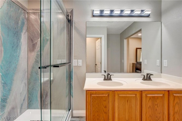 bathroom with double vanity, a marble finish shower, and a sink