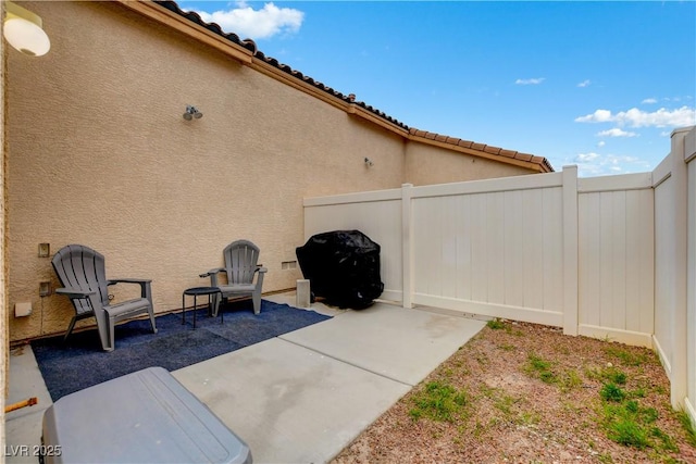 view of patio with grilling area and fence