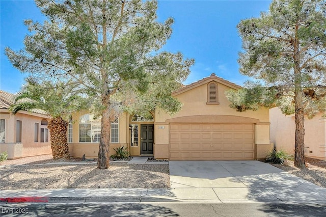 view of front of property featuring concrete driveway, a tile roof, an attached garage, and stucco siding