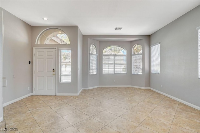 entryway with light tile patterned floors, visible vents, and baseboards