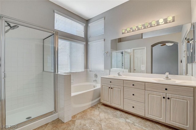 full bathroom featuring a stall shower, a garden tub, a sink, and double vanity