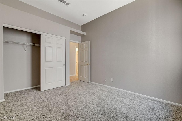 unfurnished bedroom featuring a closet, carpet, visible vents, and baseboards