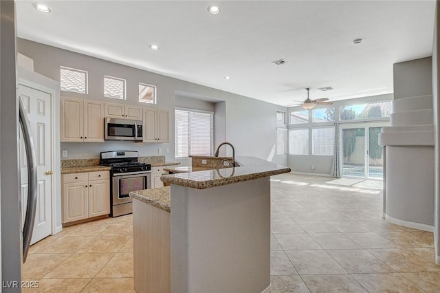 kitchen with plenty of natural light, appliances with stainless steel finishes, a ceiling fan, and light tile patterned flooring