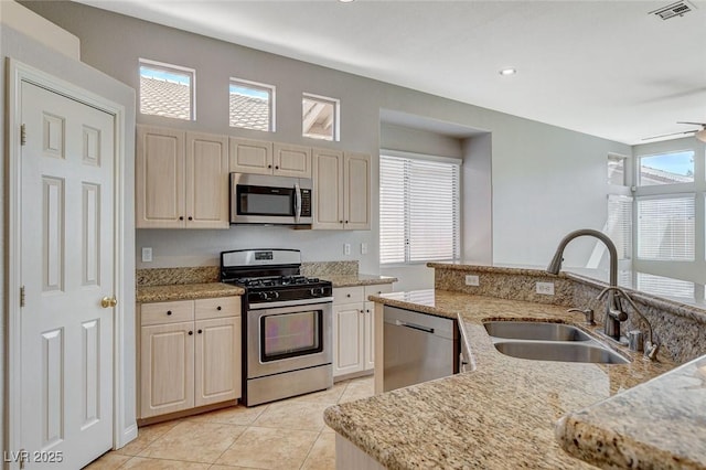 kitchen featuring light tile patterned floors, stainless steel appliances, a wealth of natural light, visible vents, and a sink