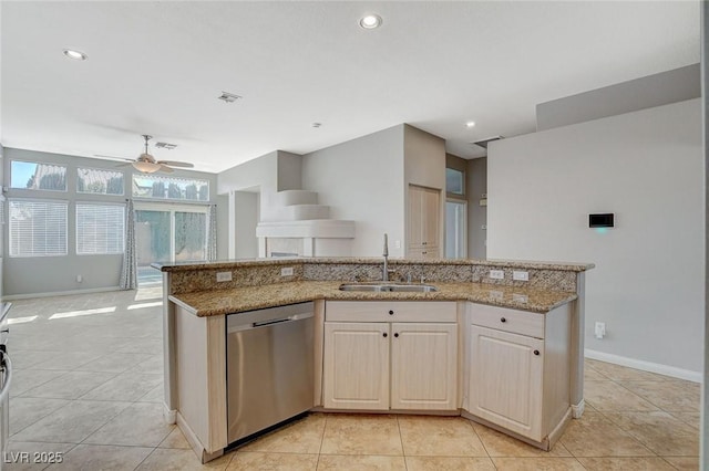 kitchen featuring a sink, light tile patterned floors, light stone counters, and dishwasher