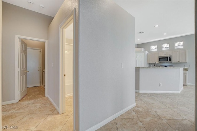 hallway featuring light tile patterned floors, recessed lighting, visible vents, and baseboards