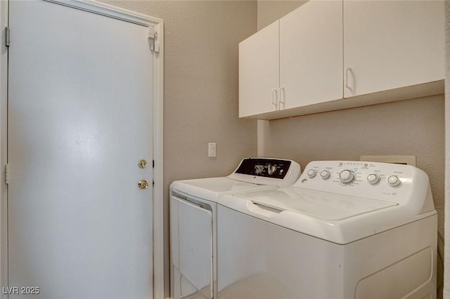 laundry room with washer and clothes dryer and cabinet space