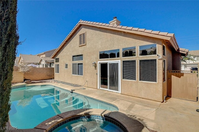 rear view of property with an in ground hot tub, fence, a fenced in pool, and stucco siding