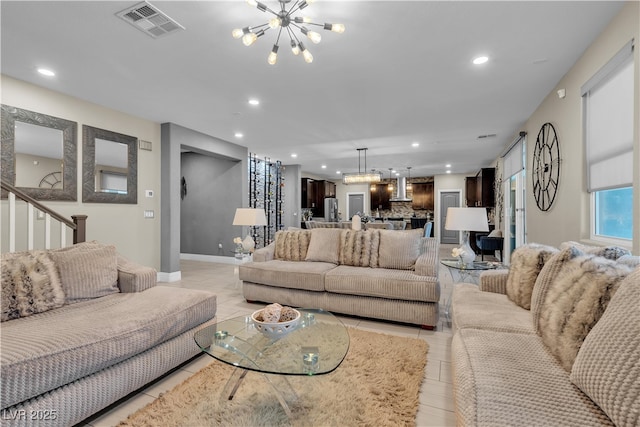 living room featuring recessed lighting, visible vents, and an inviting chandelier