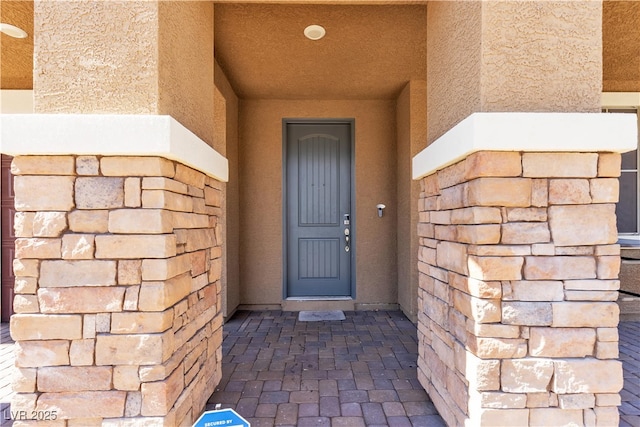 doorway to property featuring stucco siding