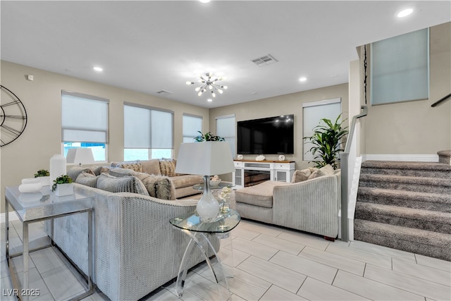 living area featuring recessed lighting, visible vents, baseboards, stairway, and an inviting chandelier