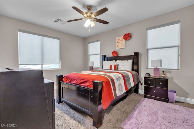 carpeted bedroom featuring ceiling fan, visible vents, and baseboards