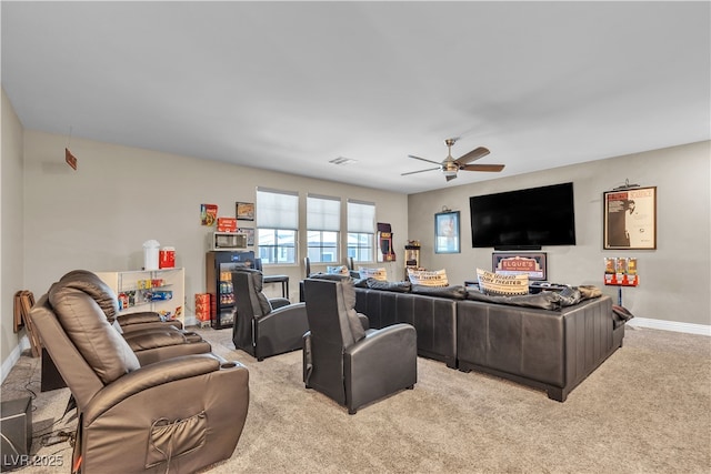 living room with a ceiling fan, light colored carpet, visible vents, and baseboards