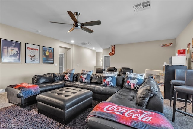 living area featuring carpet, visible vents, and a ceiling fan