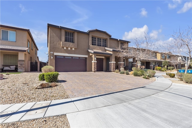 view of front facade featuring a garage, stone siding, cooling unit, decorative driveway, and stucco siding