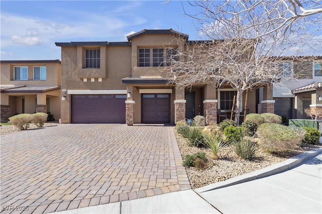 view of front of home with stone siding, decorative driveway, an attached garage, and stucco siding