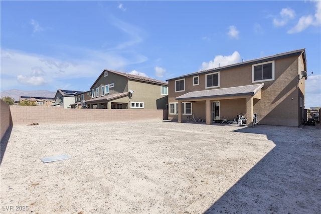 back of property featuring a fenced backyard and stucco siding