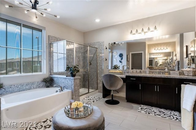 bathroom with a garden tub, a notable chandelier, a shower stall, and vanity