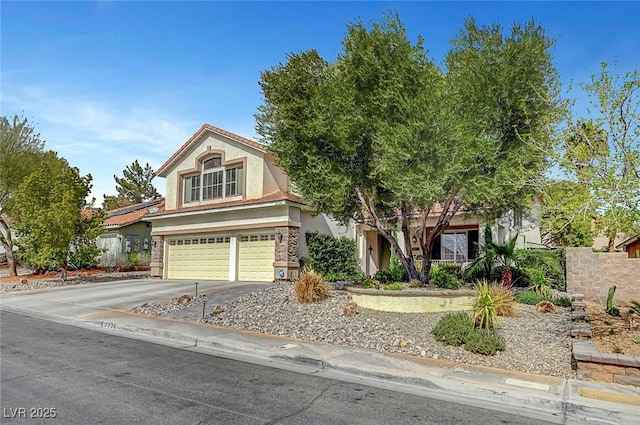 view of front of house featuring driveway, an attached garage, and stucco siding