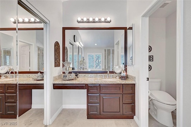 bathroom with toilet, vanity, visible vents, and tile patterned floors