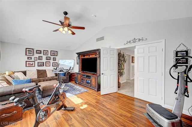 living room with lofted ceiling, ceiling fan, visible vents, and wood finished floors