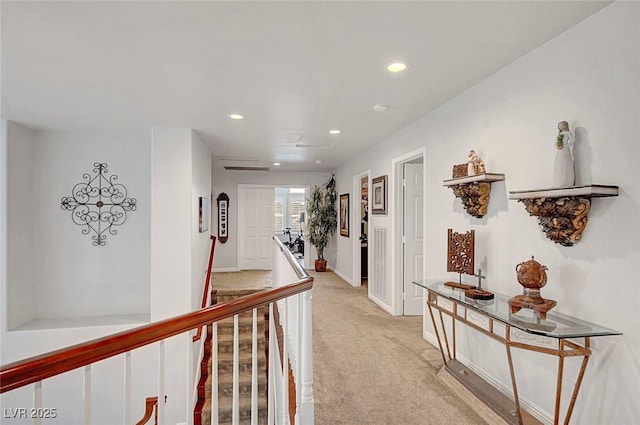 hallway with recessed lighting, an upstairs landing, and light colored carpet