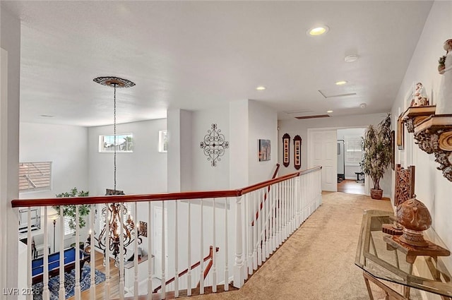 hall with an inviting chandelier, recessed lighting, an upstairs landing, and light colored carpet