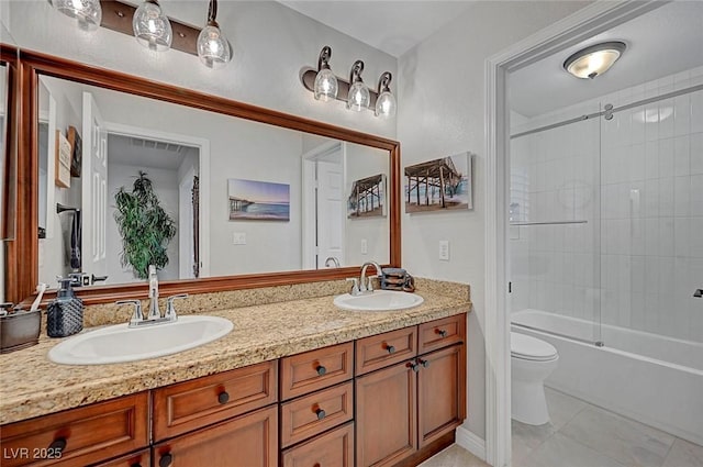 bathroom featuring double vanity, tile patterned flooring, a sink, and toilet