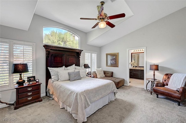 bedroom with light carpet, ensuite bath, lofted ceiling, and baseboards