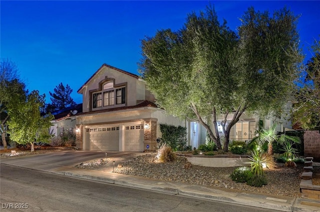 view of front facade featuring a garage, driveway, and stucco siding