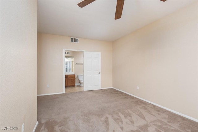 unfurnished bedroom featuring light carpet, visible vents, baseboards, a ceiling fan, and ensuite bath