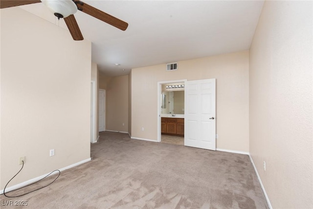 spare room with a ceiling fan, light colored carpet, visible vents, and baseboards