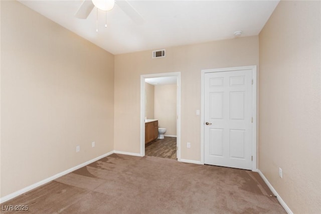 unfurnished bedroom with baseboards, visible vents, carpet flooring, and ensuite bathroom