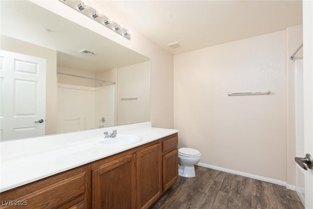 full bath with visible vents, toilet, vanity, wood finished floors, and walk in shower