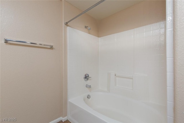 bathroom with shower / bathtub combination and baseboards