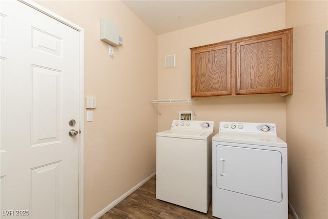 laundry area featuring dark wood-style floors, cabinet space, visible vents, washing machine and dryer, and baseboards