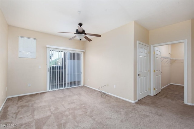 carpeted spare room featuring a ceiling fan and baseboards