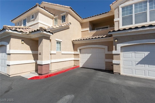 view of front of property with a garage, a balcony, and stucco siding