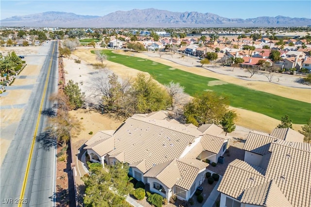 drone / aerial view with view of golf course, a residential view, and a mountain view