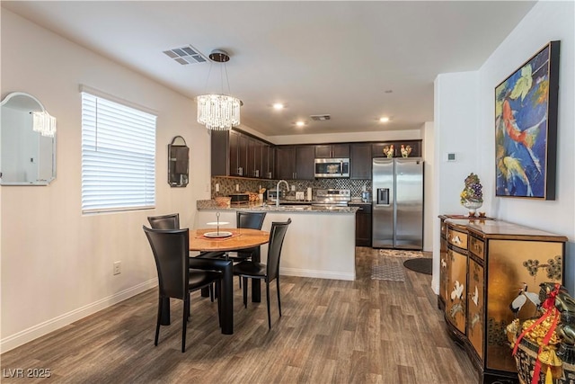 dining area with visible vents, dark wood finished floors, and baseboards