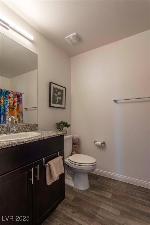 full bath with toilet, wood finished floors, vanity, visible vents, and baseboards