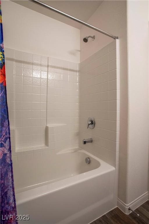 bathroom featuring shower / bath combo, baseboards, and wood finished floors