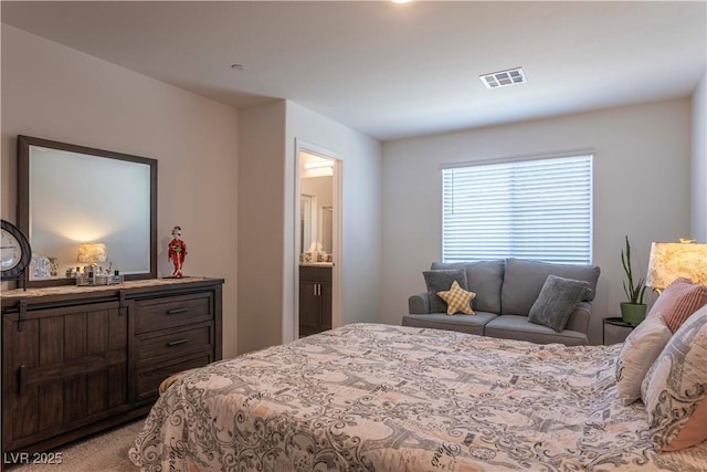 bedroom featuring visible vents, light carpet, and ensuite bathroom