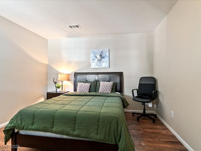 bedroom featuring visible vents, baseboards, and wood finished floors