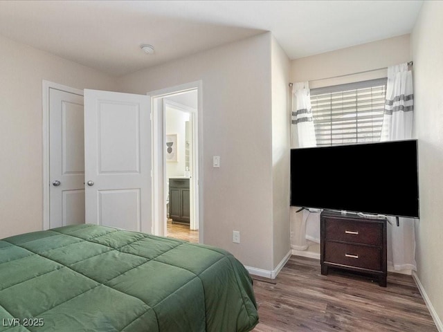 bedroom featuring baseboards and wood finished floors