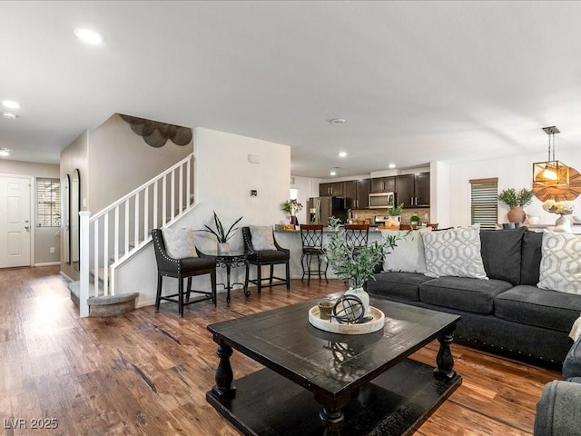 living area featuring recessed lighting, stairway, and wood finished floors